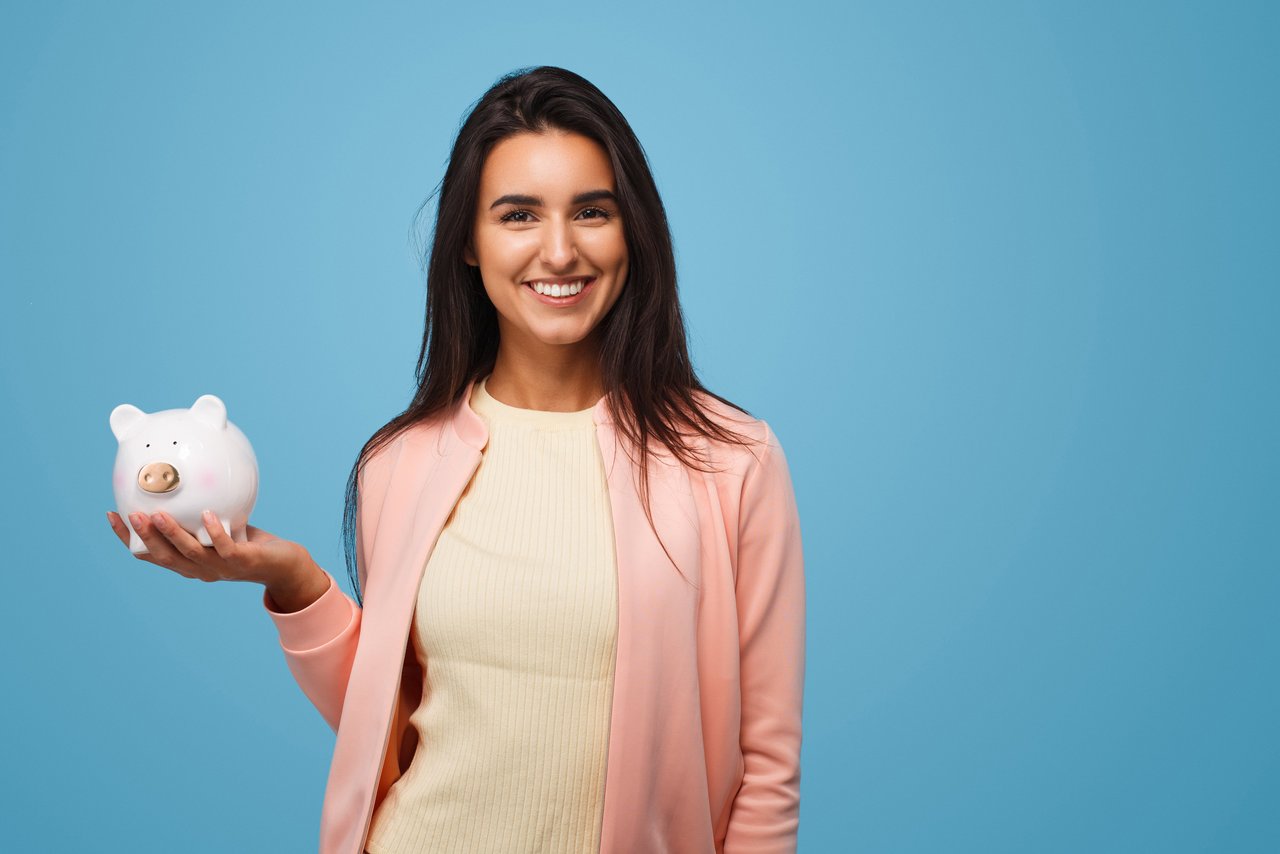 Pretty brunette with moneybox in hands