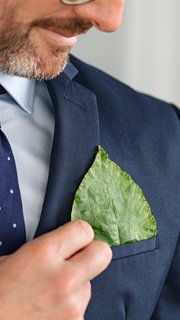 Business man keeping green leaf in pocket