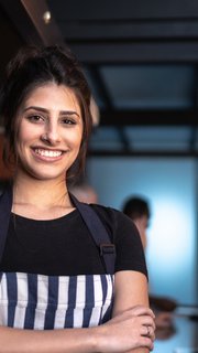 Portrait of a waitress standing with arms crossed