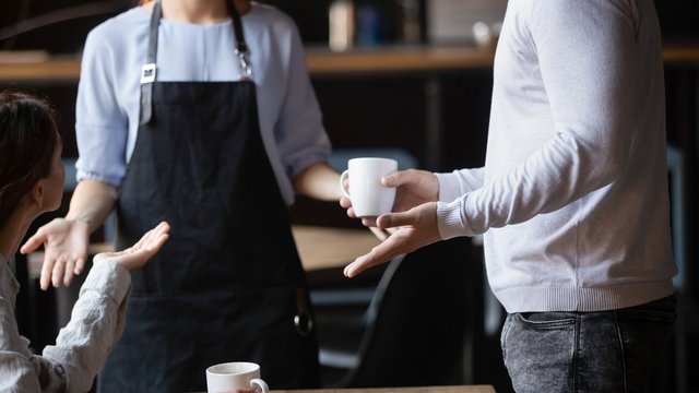 Close up outraged customers arguing with waitress, bad service concept